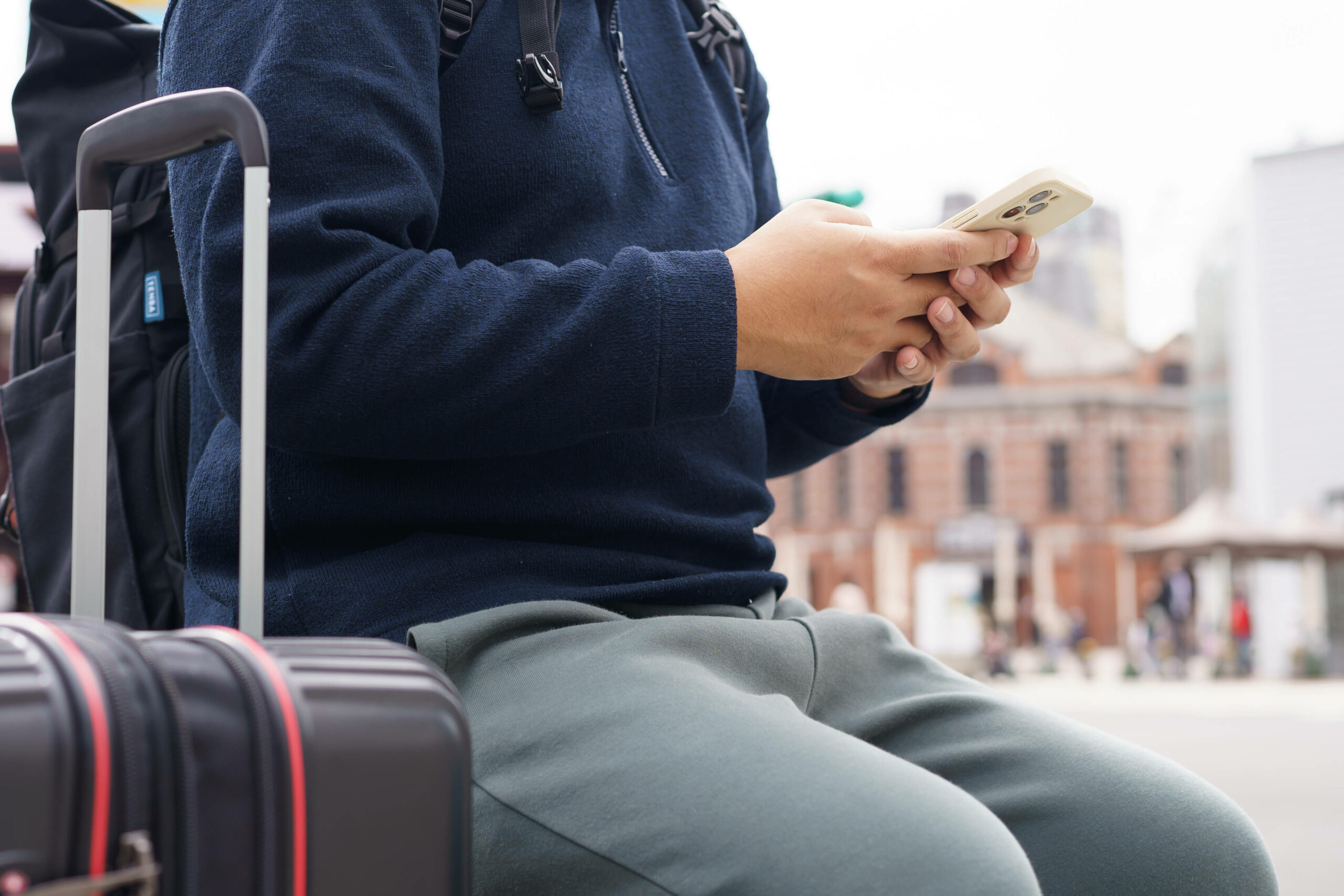 Ein Urlauber hält sein Smartphone in der Hand.