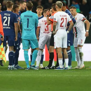Schiedsrichter Felix Brych ruft die Spieler von Augsburg und Hoffenheim zusammen.