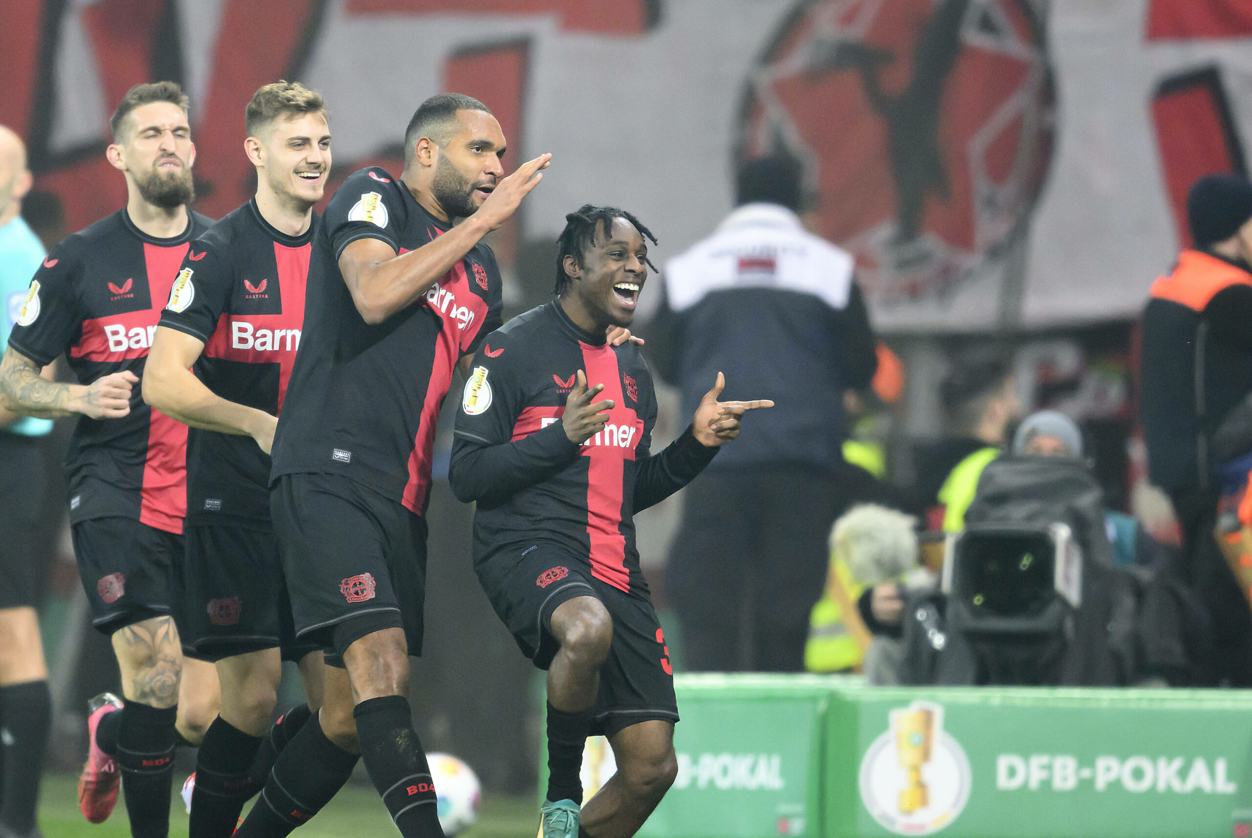 Leverkusens Spieler Robert Andrich, Josip Stanisic und Jonathan Tah feiern mit Jeremie Frimpong zusammen sein Tor