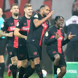 Leverkusens Spieler Robert Andrich, Josip Stanisic und Jonathan Tah feiern mit Jeremie Frimpong zusammen sein Tor