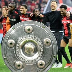 Die Leverkusener Spieler feiern mit ihren Fans vor der Kurve.