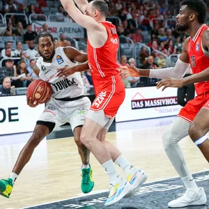 Aljami Durham versucht sich gegen zwei Bamberger Spieler durchzusetzen.