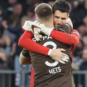St. Pauli-Torwart Nikola Vasilj umarmt Mitspieler Karol Mets nach dem Sieg gegen Rostock