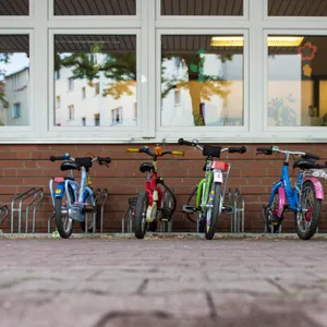 Kinderfahrräder stehen vor einer Kita. (Symbolfoto)