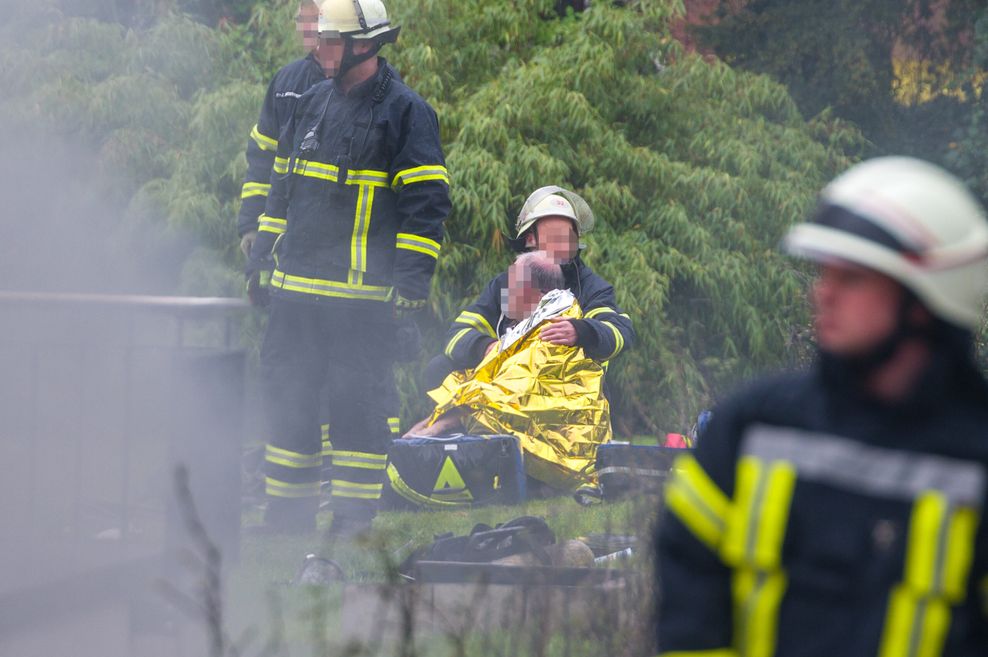 Ein verletzter Feuerwehrmann wird von Kollegen betreut. Er kam danach ins Krankenhaus.