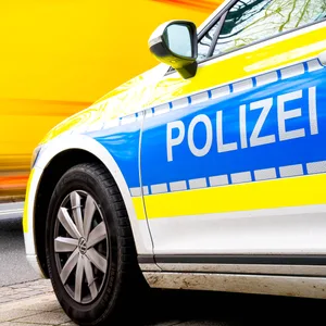 Ein Einsatzfahrzeug der Polizei steht an einer Straße.