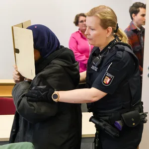 Itzehoe: Zum Prozessauftakt wegen Totschlags wird die Angeklagte (l.) zu ihrem Sitzplatz geführt.