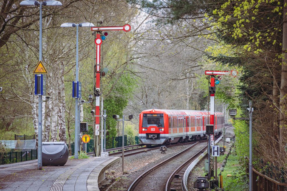 Eine S-Bahn fährt in den Bahnhof Sülldorf ein. Rechts und links im Bild: Die rot-weißen „Formsignale“.