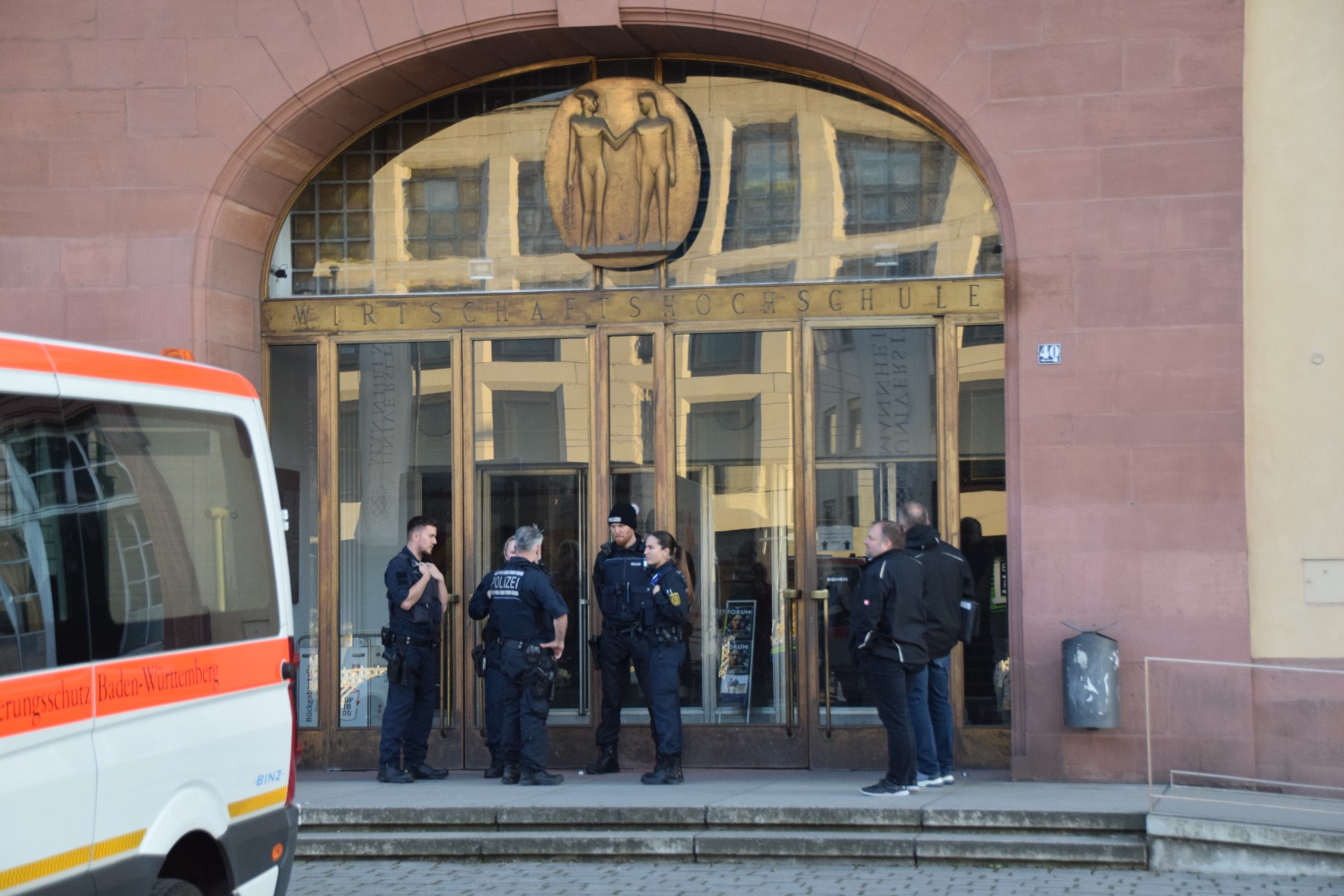 Polizisten stehen vor der Uni-Bibliothek in Mannheim. Dort hatte ein Mann Beamte mit einer Machete bedroht – diese griffen zur Dienstwaffe.