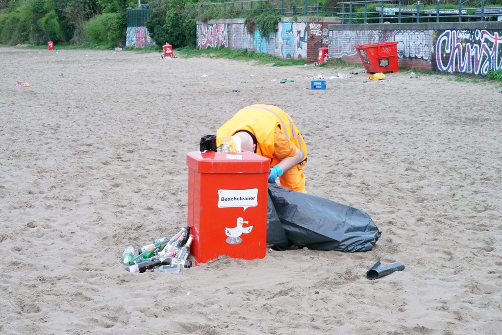 Ein Mitarbeiter der Stadtreinigung räumt am Elbstrand den Müll auf.