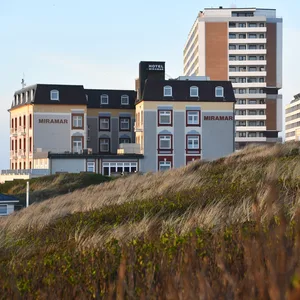 Westerland: Häuser und das Hotel Miramar, aufgenommen hinter den Dünen in der Abendsonne.