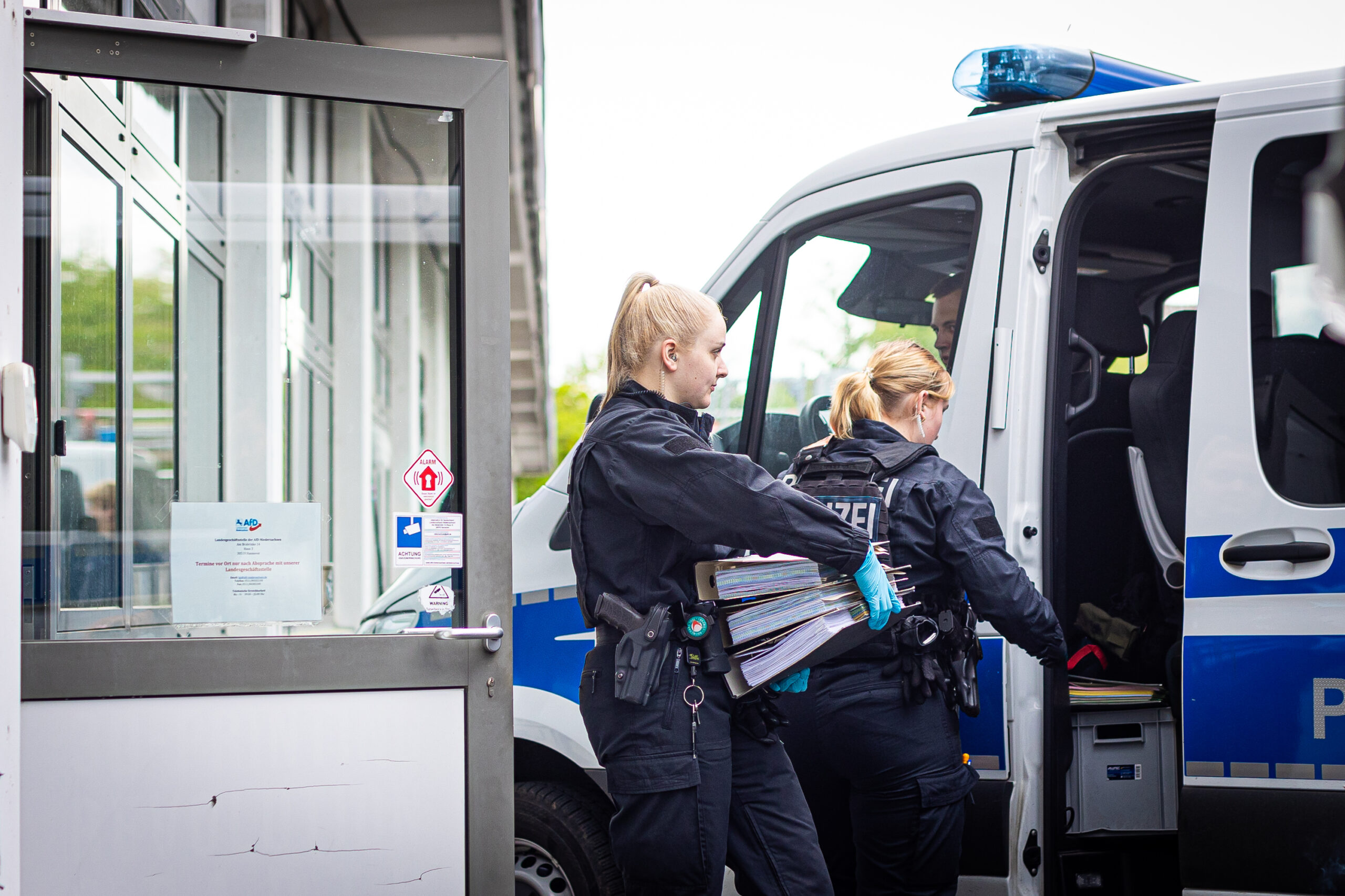 Polizistinnen tragen Aktenordner aus der AfD-Zentrale in Hannoover.