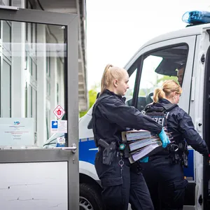 Polizistinnen tragen Aktenordner aus der AfD-Zentrale in Hannoover.