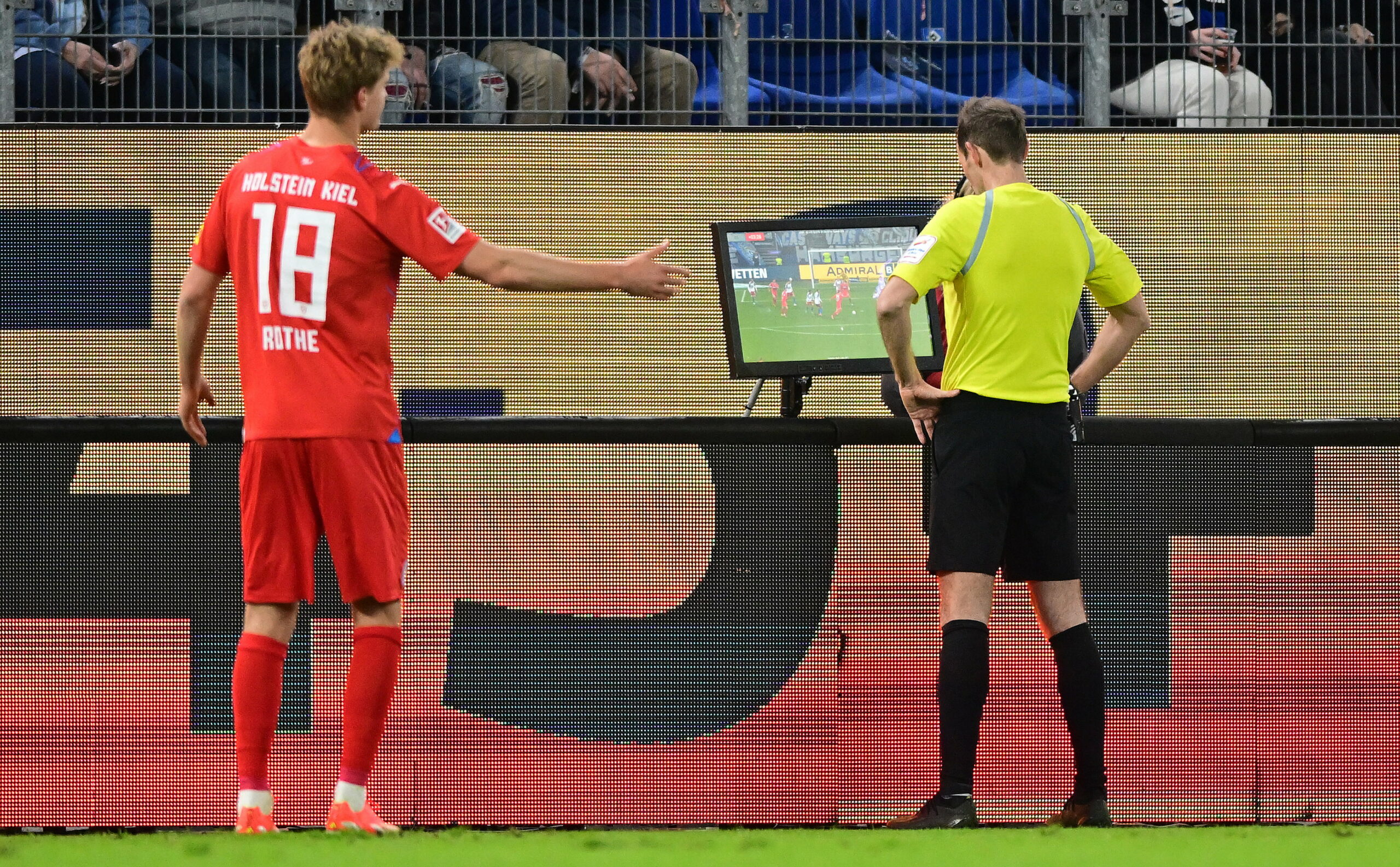 Schiedsrichter Sascha Stegemann schaut sich nach Tom Rothes Treffer zum 1:0 gegen Kiel die Szene noch mal im Video an.