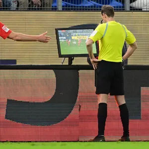 Schiedsrichter Sascha Stegemann schaut sich nach Tom Rothes Treffer zum 1:0 gegen Kiel die Szene noch mal im Video an.