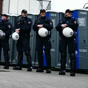 Polizisten stehen vor Dixi-Klos an der Nordtribüne des Millerntorstadions.