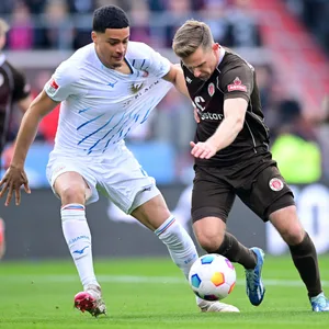 St. Pauli-Stürmer Johannes Eggestein kämpft mit dem Rostocker Jonas David verbissen um den Ball