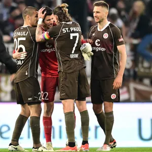 St. Pauli-Profis feiern Nikola Vasilj nach dem Sieg gegen Rostock