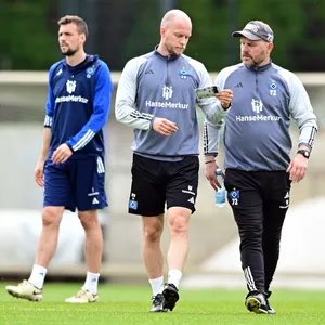 René Wagner und Steffen Baumgart gucken im HSV-Training auf einen Taktikzettel