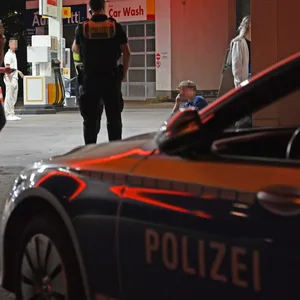Das Opfer sitzt vor dem Eingang der Tankstelle und telefoniert.