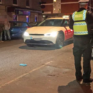 Polizisten untersuchen das Taxi nach dem Unfall auf dem Hamburger Berg.