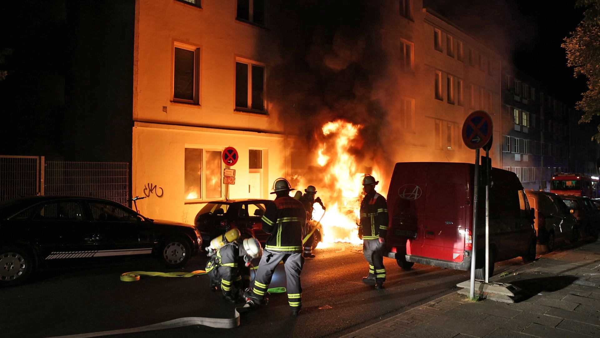 Feuerwehrkräfte löschen die Flammen vor dem Harburger Wohnhaus.