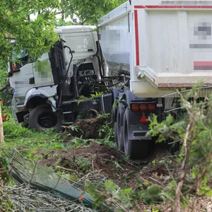 Der Kipplaster landete in einem Vorgarten. Der Fahrer musste befreit werden.