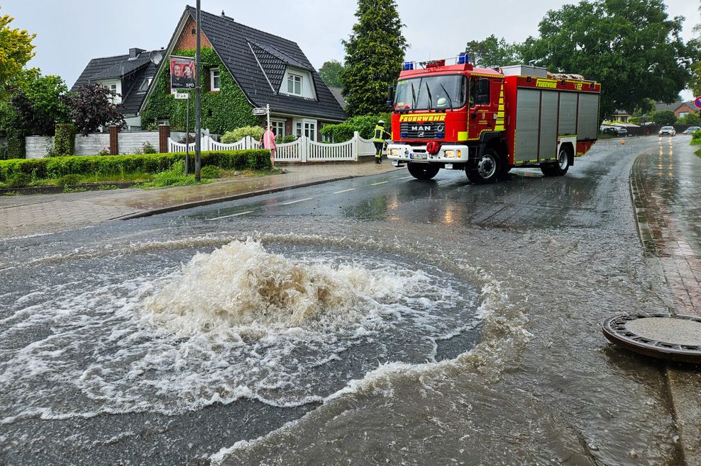 Land unter in Buchholz in der Nordheide: Auf der Bremer Straße drücken die Wassermassen Gullydeckel hoch.
