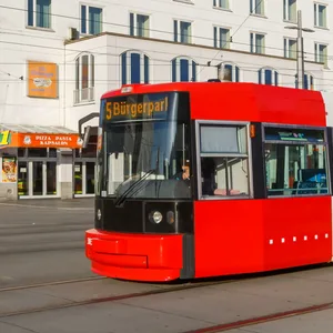 Straßenbahn vor weißem Hochhhaus