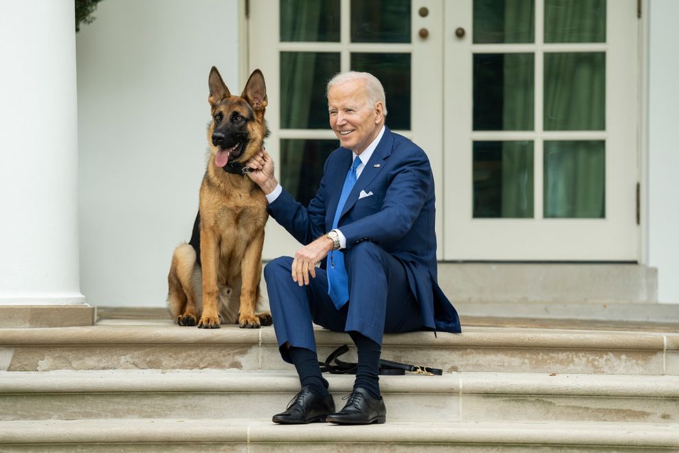 Joe Biden, Präsident der USA, sitzt mit seinem Hund „Commander“ auf den Stufen vor dem Weißen Haus.