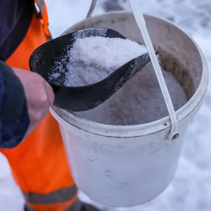 Ein Mann verteilt Streusalz bei Schneeglätte (Symbolbild).