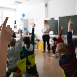 Kinder melden sich in einem Klassenzimmer