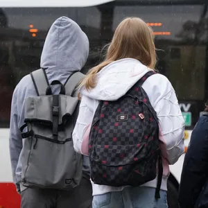 Mehrere Menschen stehen vor einem HVV-Bus (Symbolbild).