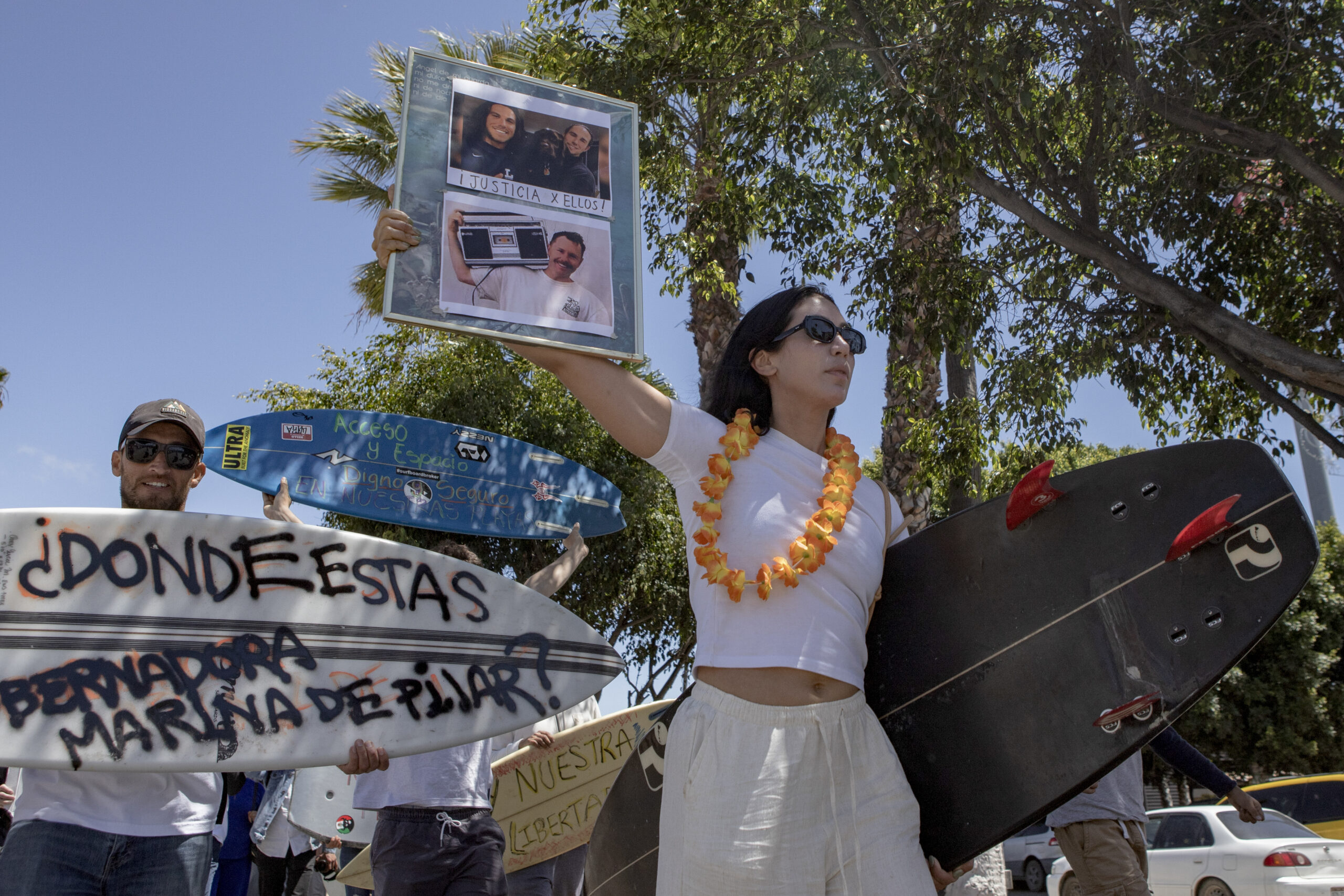 Eine Frau hält während einer Demonstration Fotos der verschwundenen ausländischen Surfer.