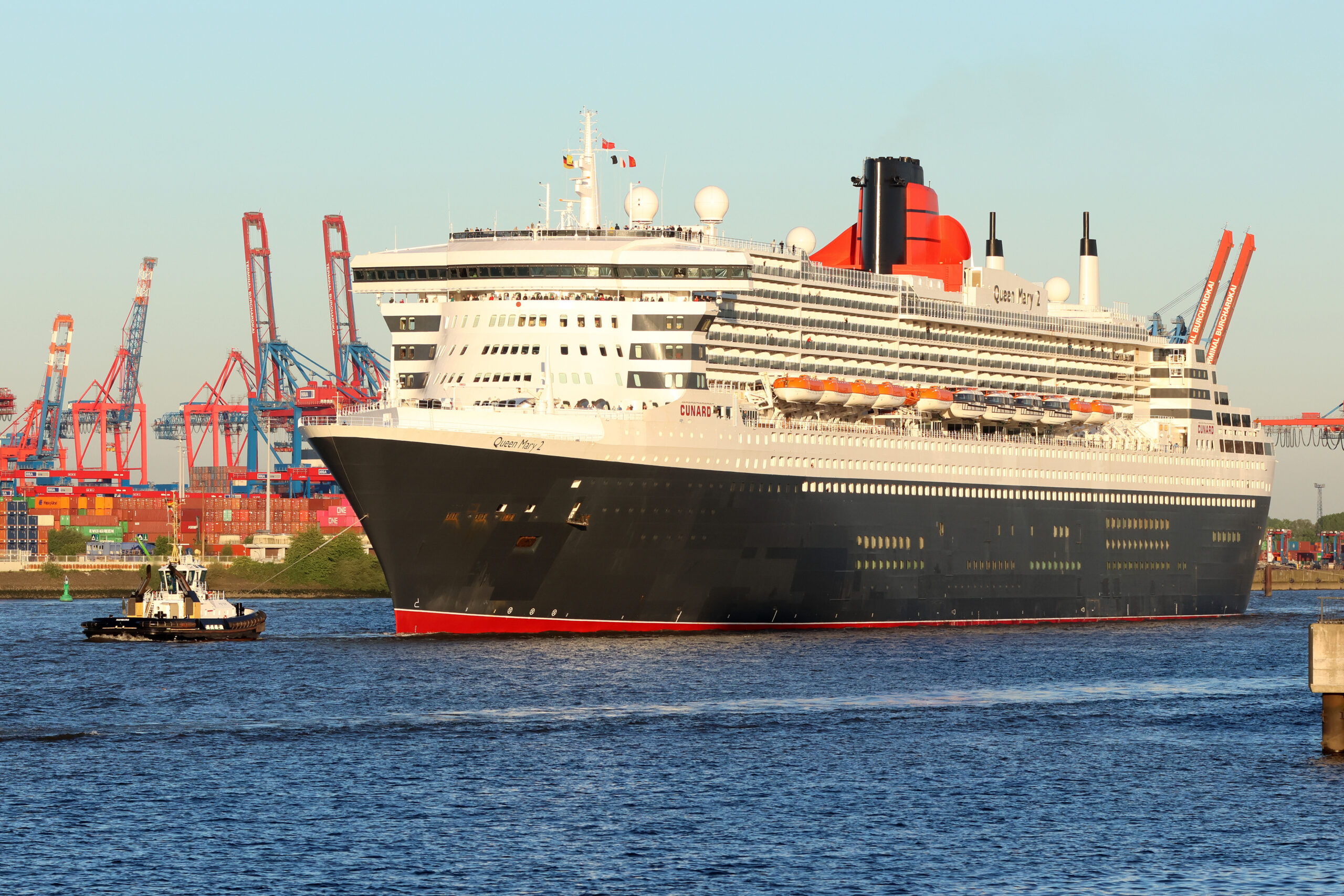 Das Kreuzfahrtschiff „Queen Mary 2“ läuft bei Sonnenschein am Morgen in den Hamburger Hafen ein.