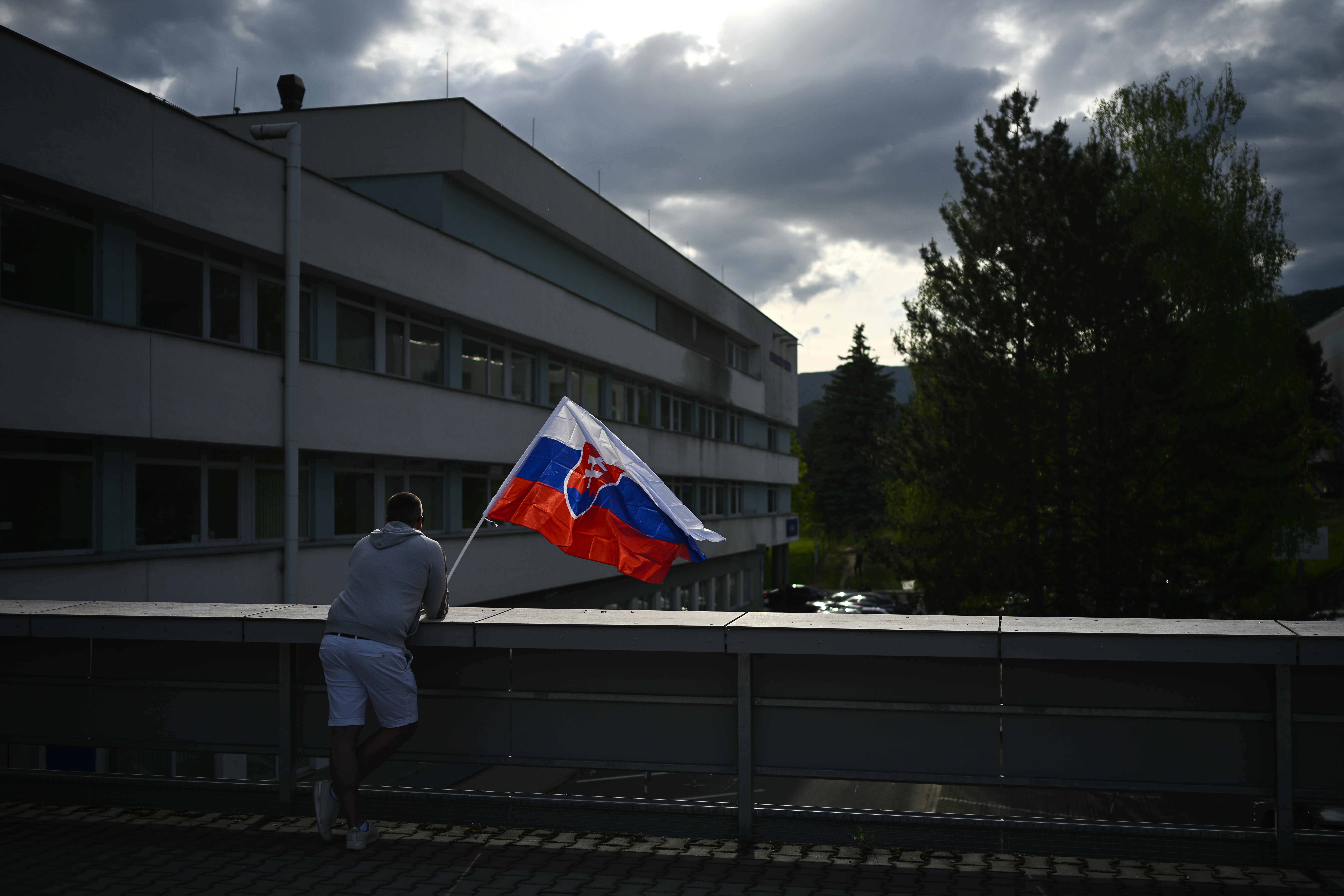 Ein Mann schwenkt die slowakische Nationalflagge vor dem F. D. Roosevelt Universitätskrankenhaus, in dem der angeschossene und verwundete slowakische Premierminister Fico behandelt wird.