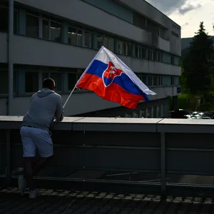 Ein Mann schwenkt die slowakische Nationalflagge vor dem F. D. Roosevelt Universitätskrankenhaus, in dem der angeschossene und verwundete slowakische Premierminister Fico behandelt wird.