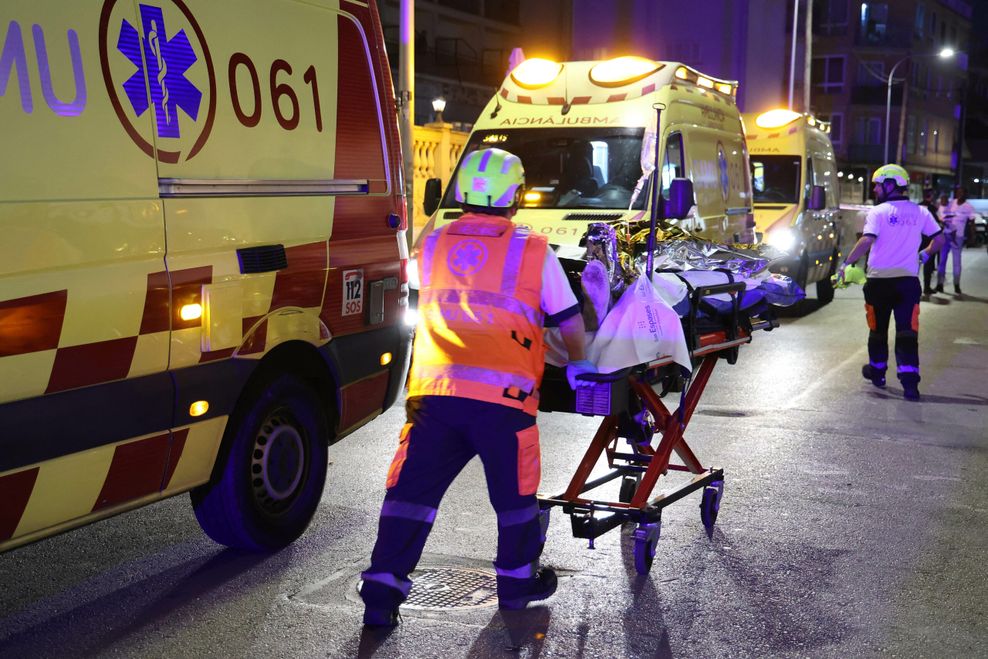 Ein Rettungssanitäter schiebt eine verletzte Person auf einer Trage.