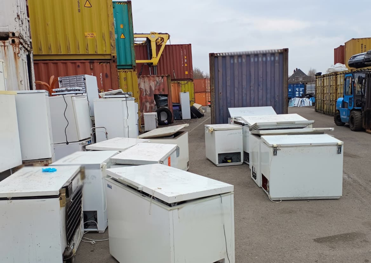 FCKW-haltige Kühlgeräte stehen auf einem Container-Umschlagplatz.