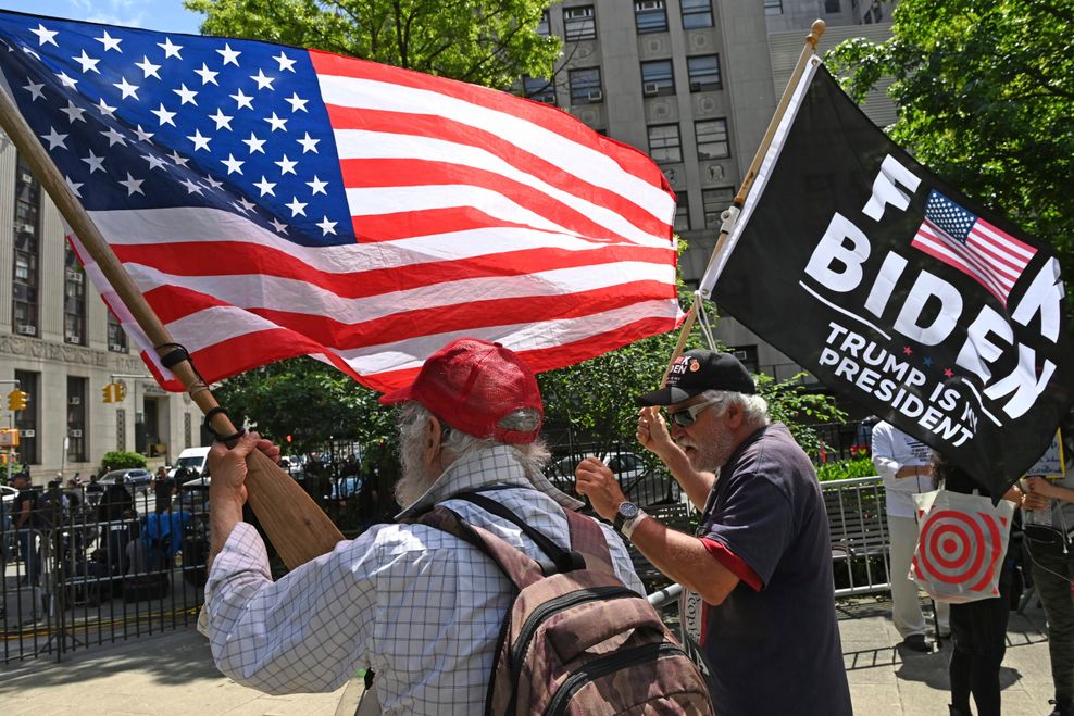 Männer in Baseball-Kappen schwenken Anti-Biden-Flagge