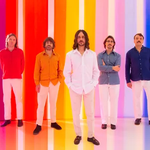 Band steht vor einem Regenbogen-farbenen Hintergrund