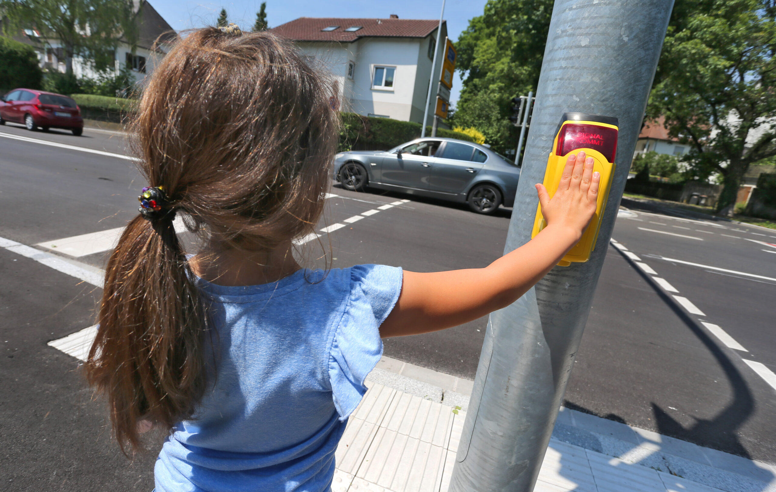 Ein kleines Mädchen steht an einer Ampel (Symbolbild).