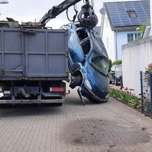 Zaun schief, Garagenwand eingedellt – und das Schrottauto ist immer noch nicht auf dem Lastwagen ...