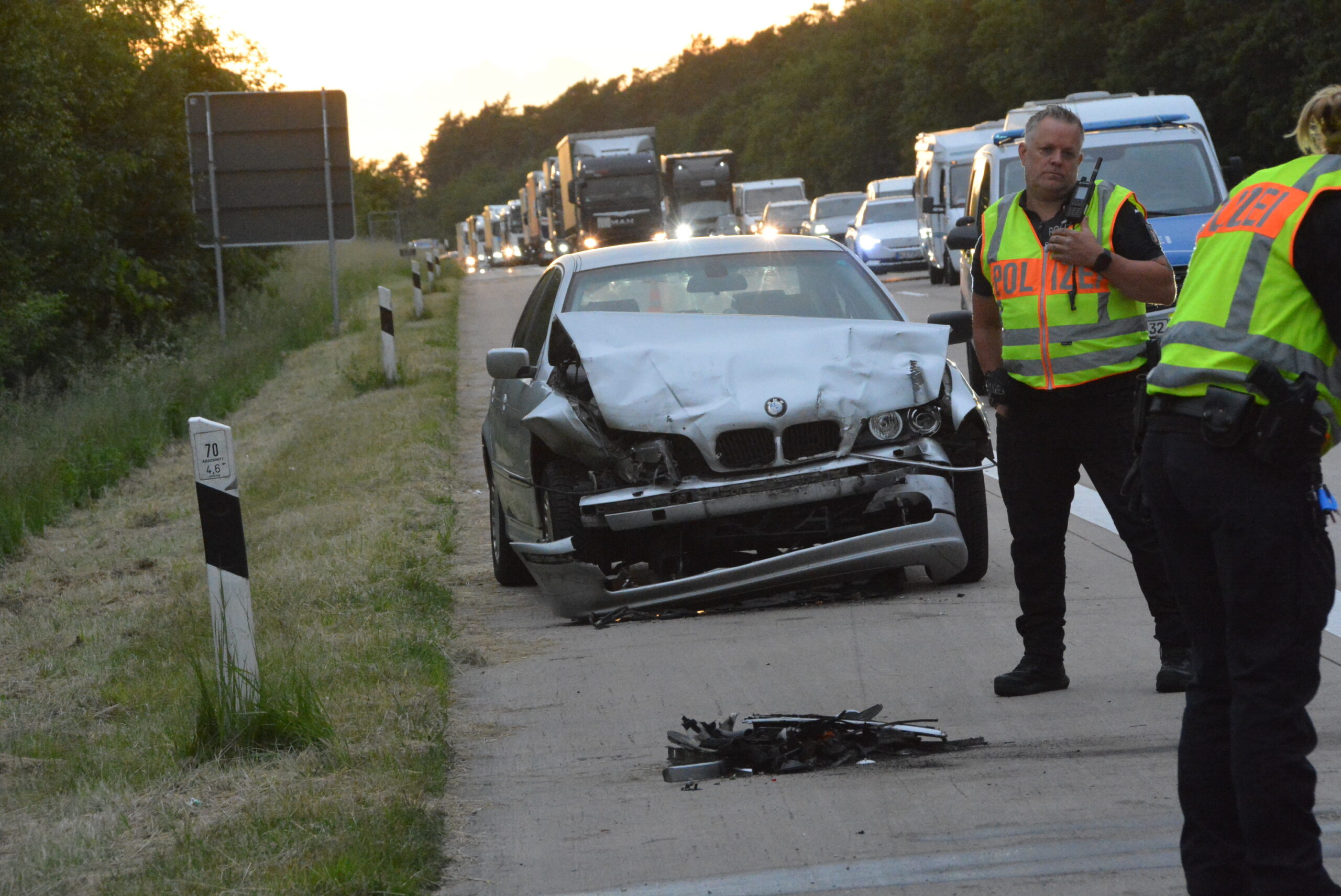 Polizisten an zerbeultem silbernen BMW