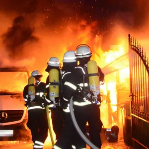 Flammen schlagen aus dem Carport und drohen, auf das Haus überzugreifen.
