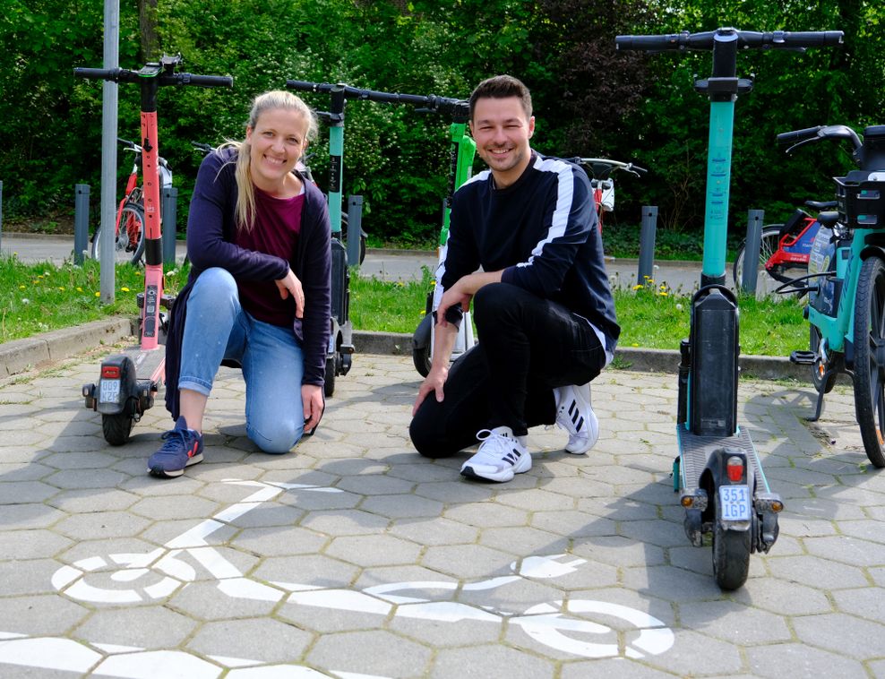 Katharina Fischer-Zernin (Grüne) und Momme Dähne (SPD) an einer Abstellfläche für E-Scooter an der U-Bahnstation Langenhorn Nord.