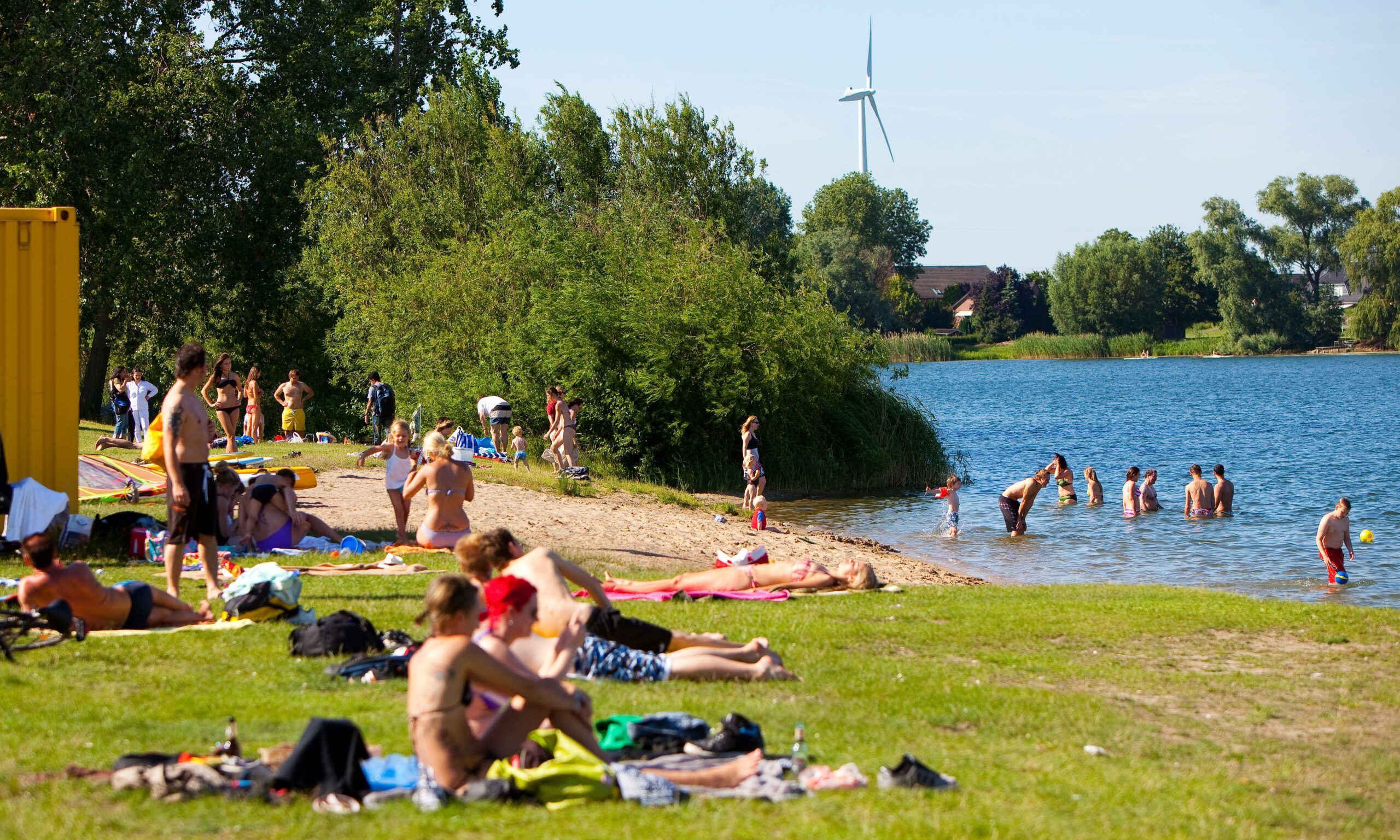 Menschen liegen an einer Badestelle am Hohendeicher See.