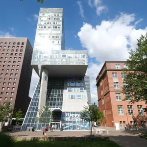 Modernes Glasgebäude zwischen Ziegelbauten
