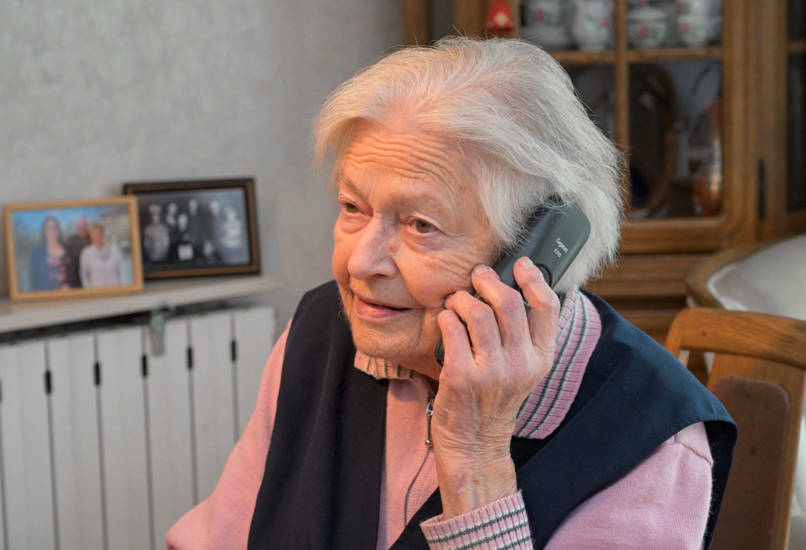 Eine Seniorin ist am Telefon.