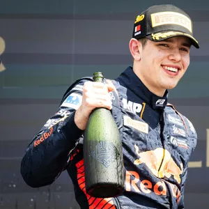 Tim Tramnitz lächelt mit Champagner-Flasche in der Hand.